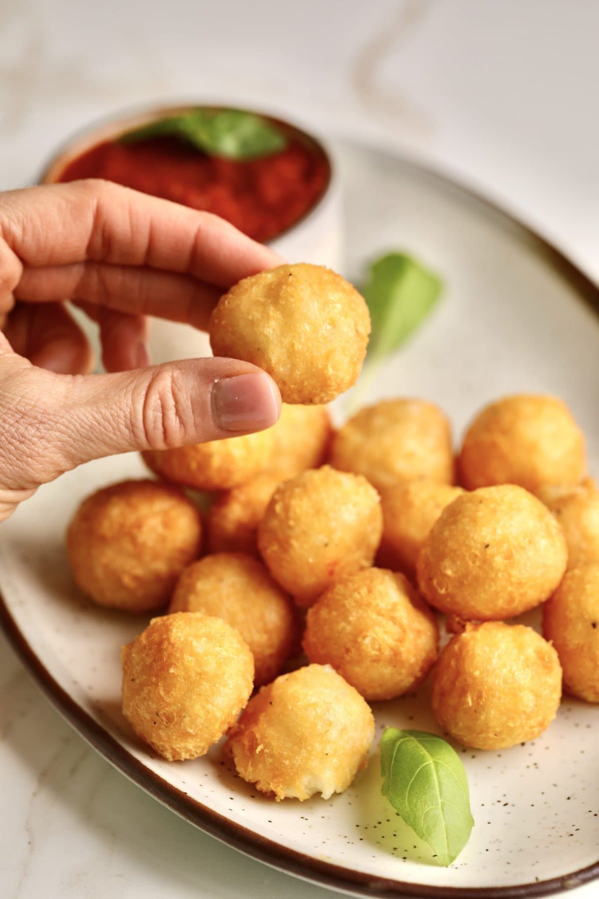 hand holding one fried cheese ball.