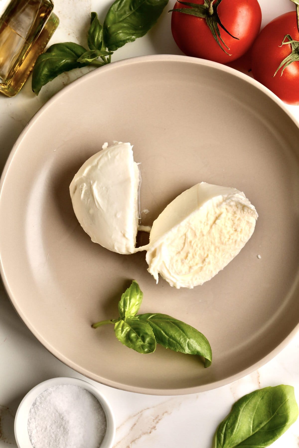 mozzarella cheese cut in half on a plate.