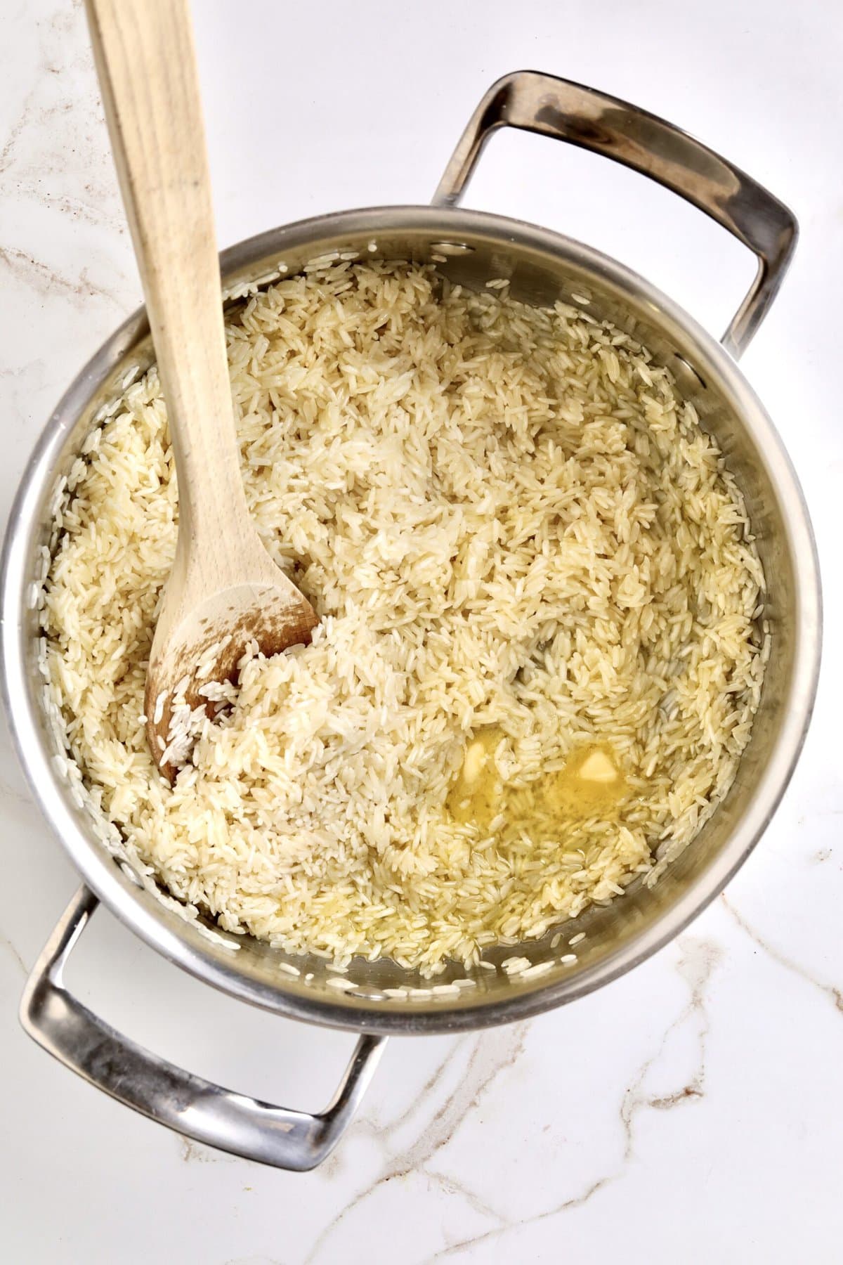 How to make Creamy Parmesan Rice Recipe (Quick and Easy Side): adding the butter and rice to the pan to toast before steaming rice.