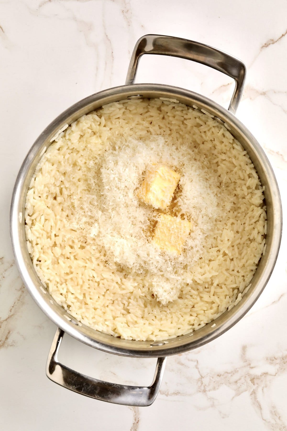 How to make Creamy Parmesan Rice Recipe (Quick and Easy Side): stirring in the butter nad cheese to the cooked rice.