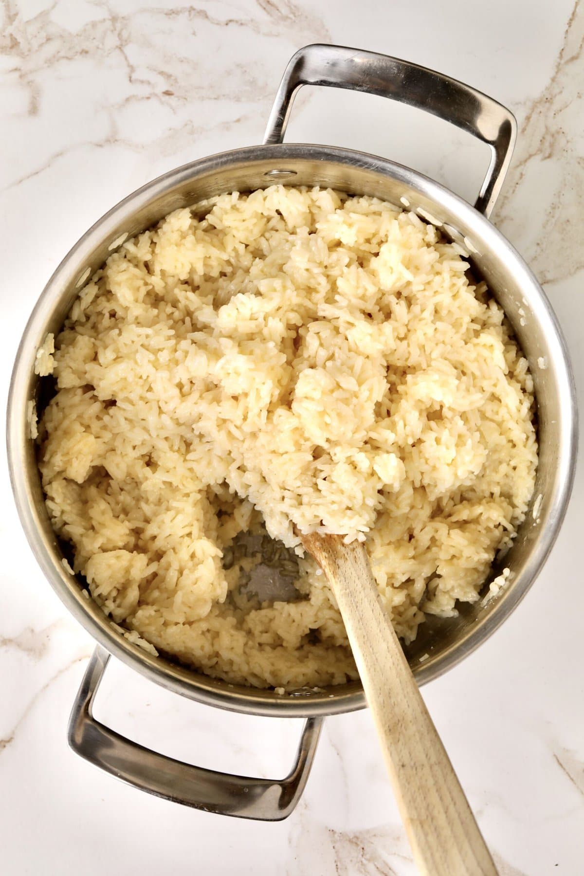 How to make Creamy Parmesan Rice Recipe (Quick and Easy Side): stirring in the butter and cheese to the cooked rice. Fluffing and mixing rice.