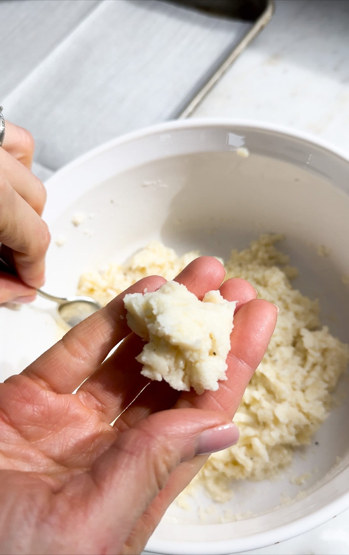 Process for making fried cheese balls- scooping up the cheese mixture with a small spoon and rolling it into a ball.