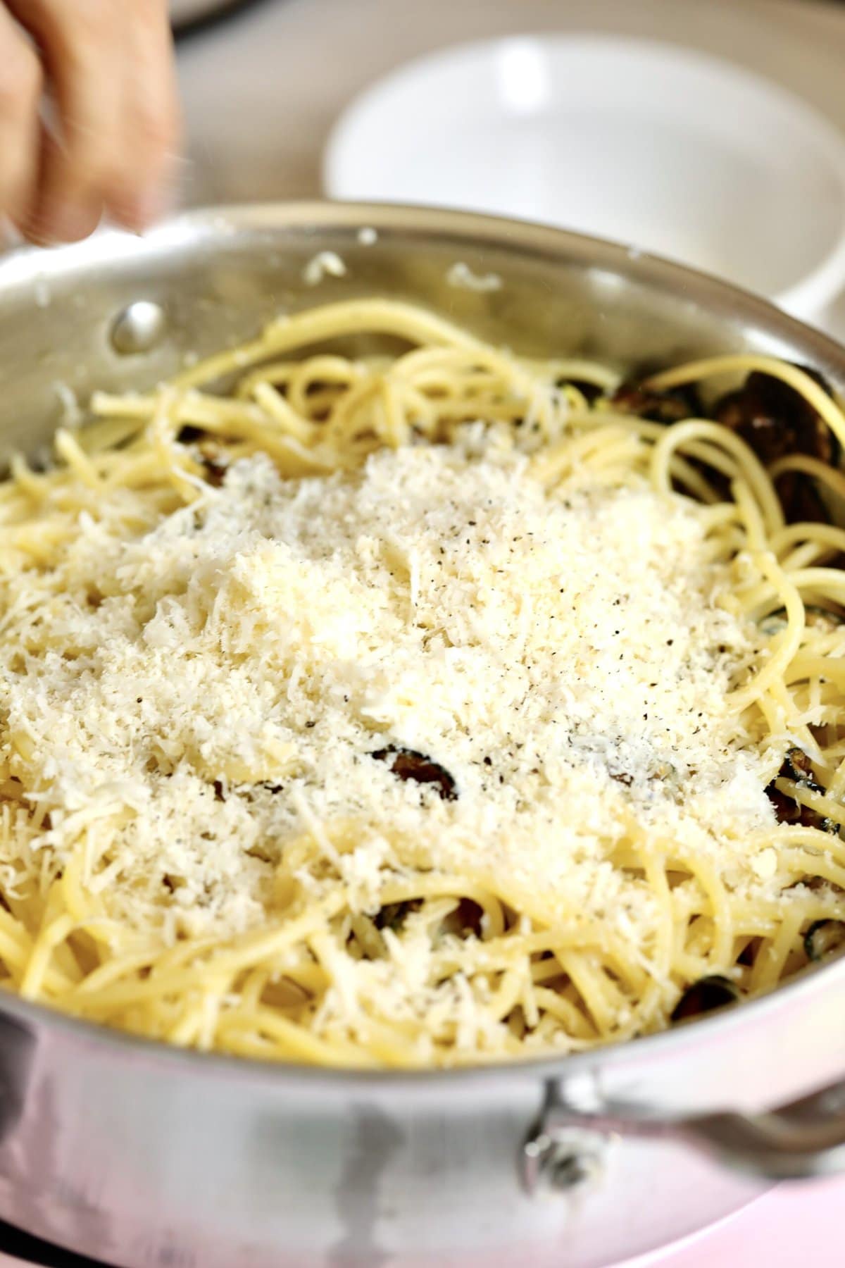 process for how to make spaghetti alla nerano- adding the cheese and stirring constantly to create a creamy sauce.