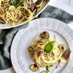 Spaghetti alla Nerano Recipe (Fried Zucchini Pasta) on a plate with a platter of the final dish in the background.