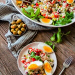 Italian rice salad on a plate with a platter of the rice salad in the background.