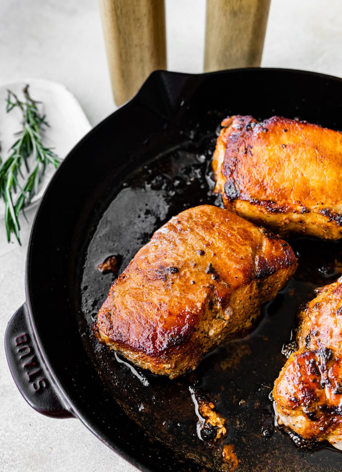 close up of pork chops in pan. perfectly cooked pork chops.