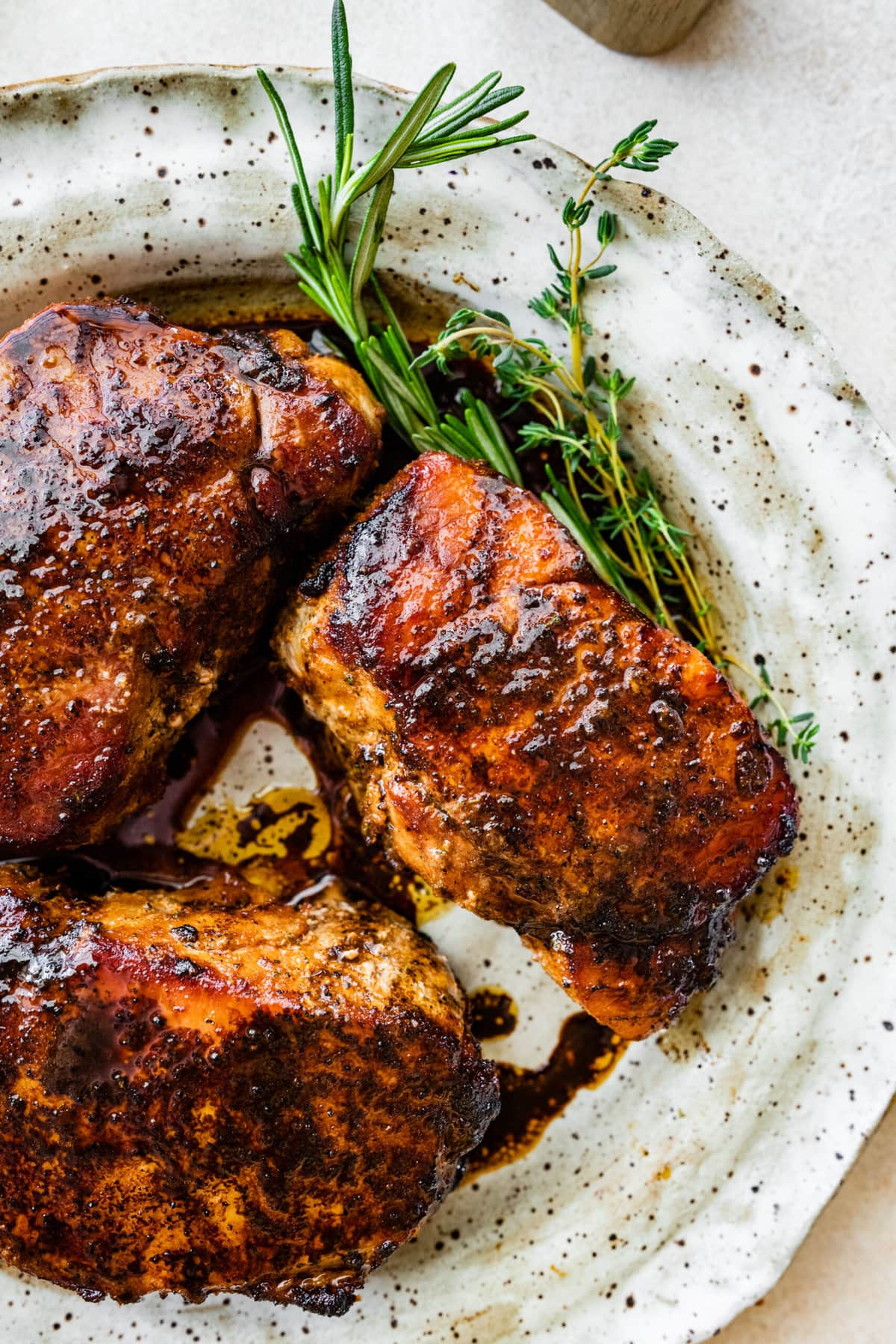 finished perfectly cooked pork chops on a white plate.