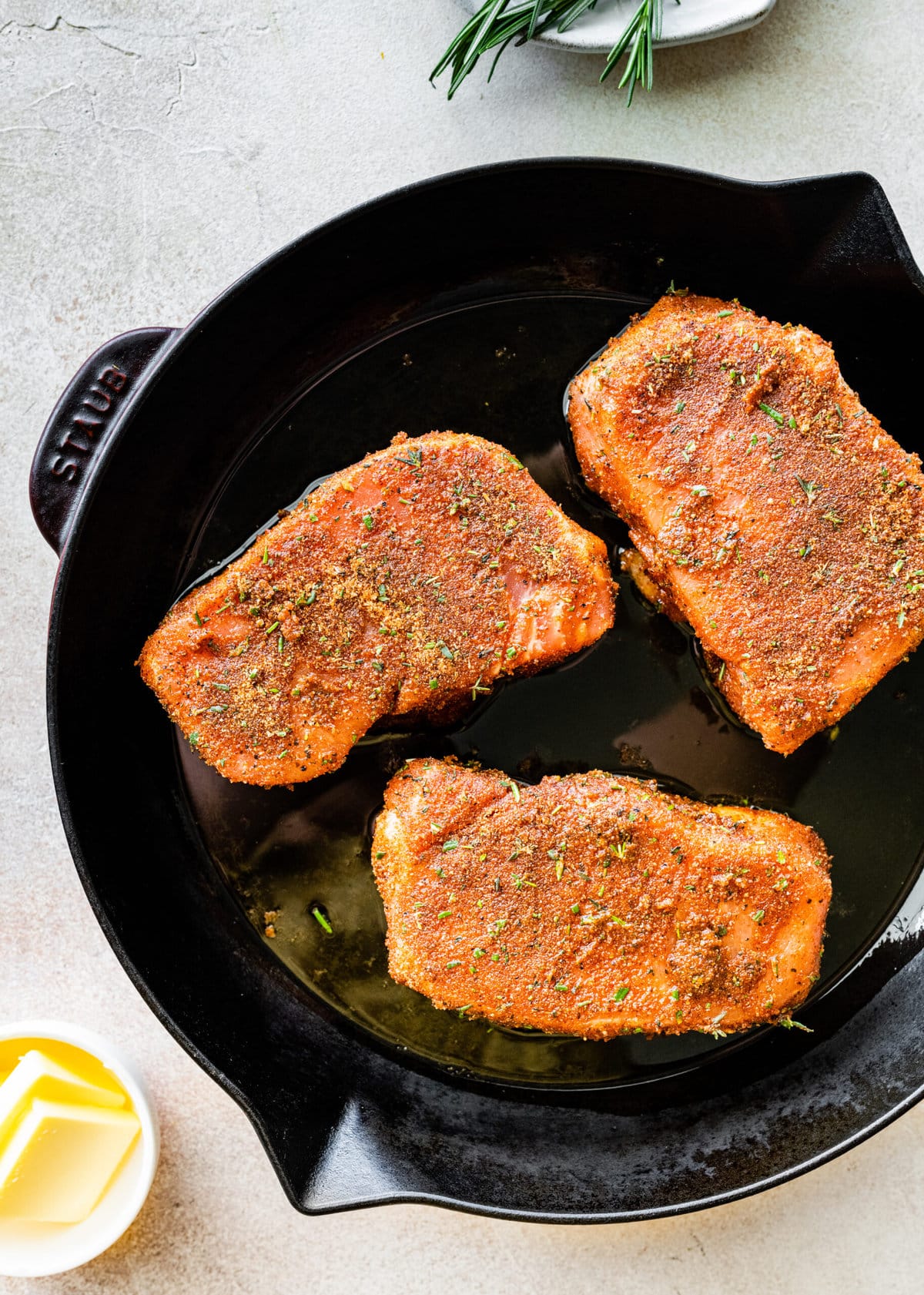 Step-by-step photos for How to cook thick pork chops- adding pork chops to hot skillet with oil.