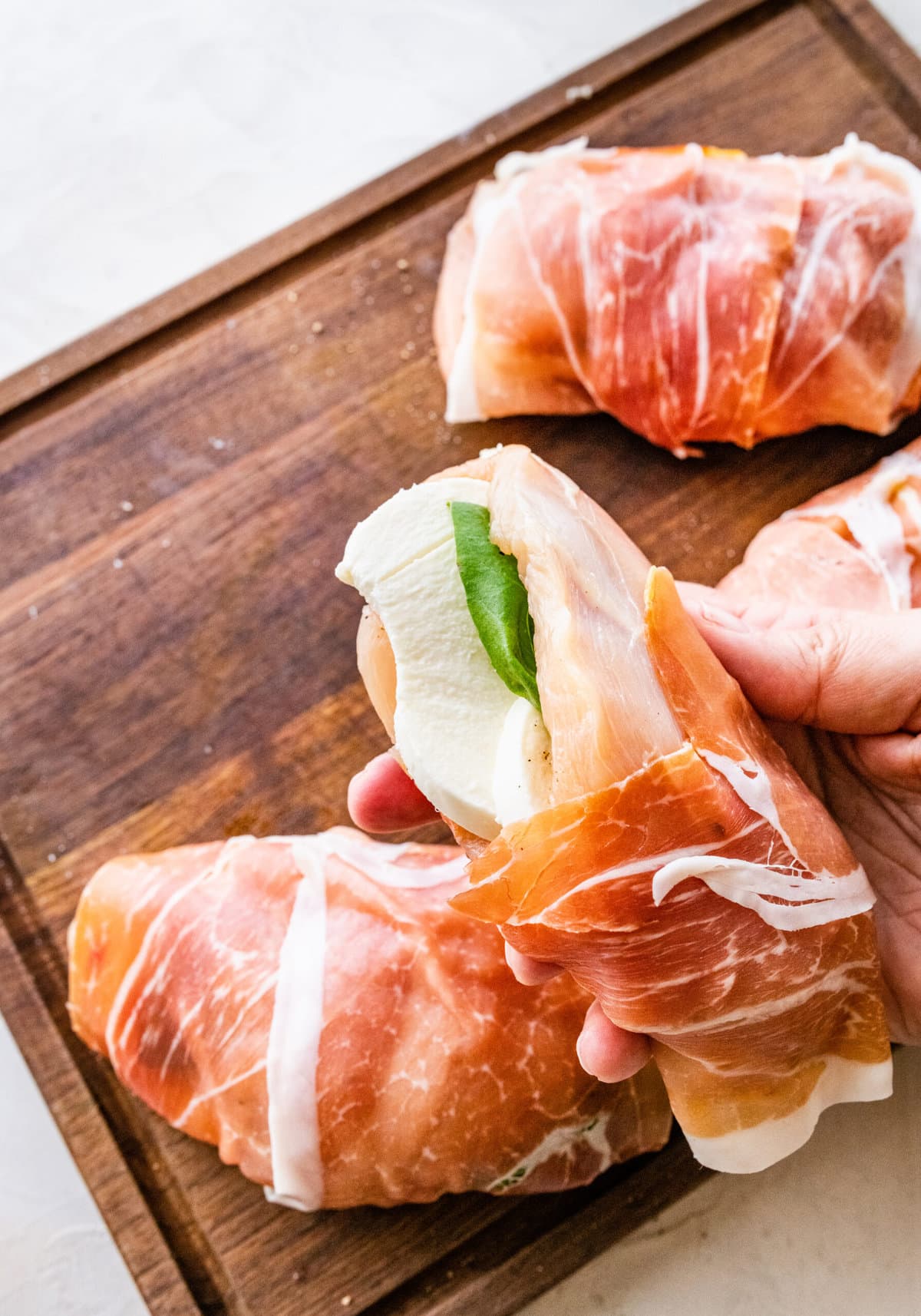 How to make Mozzarella stuffed Chicken chicken- cut chicken stuffed with mozzarella slices and basil then wrapped in prosciutto slices.