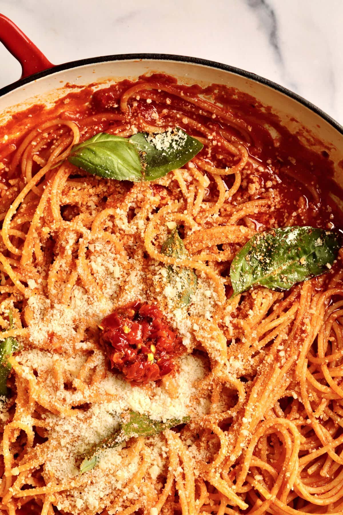 Tomato Paste Pasta topped with fresh basil and cheese.
