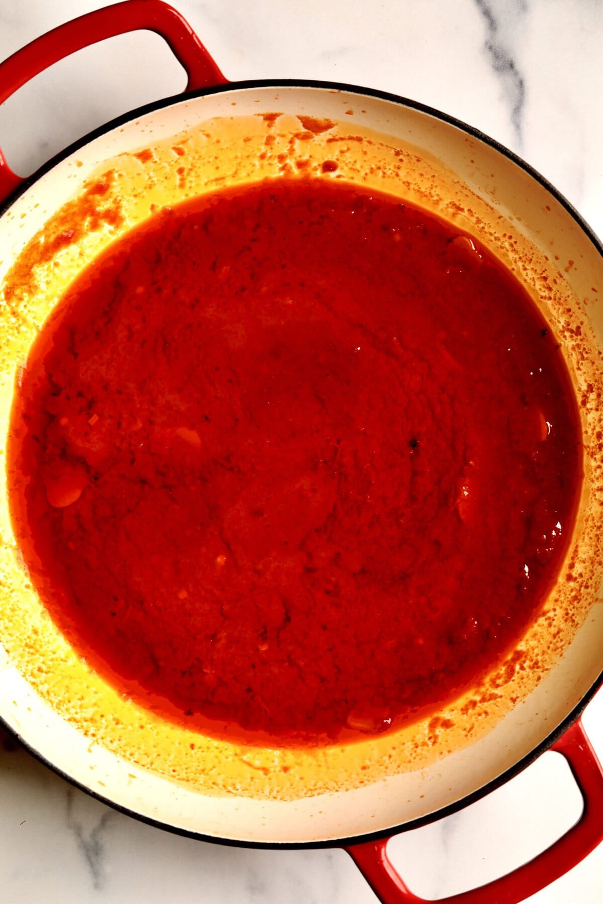 How to make: Quick Tomato Paste Pasta Sauce Recipe with Spaghetti- add the tomato paste to the pan and let it caramelize. Then, add pasta water and bring to a simmer.