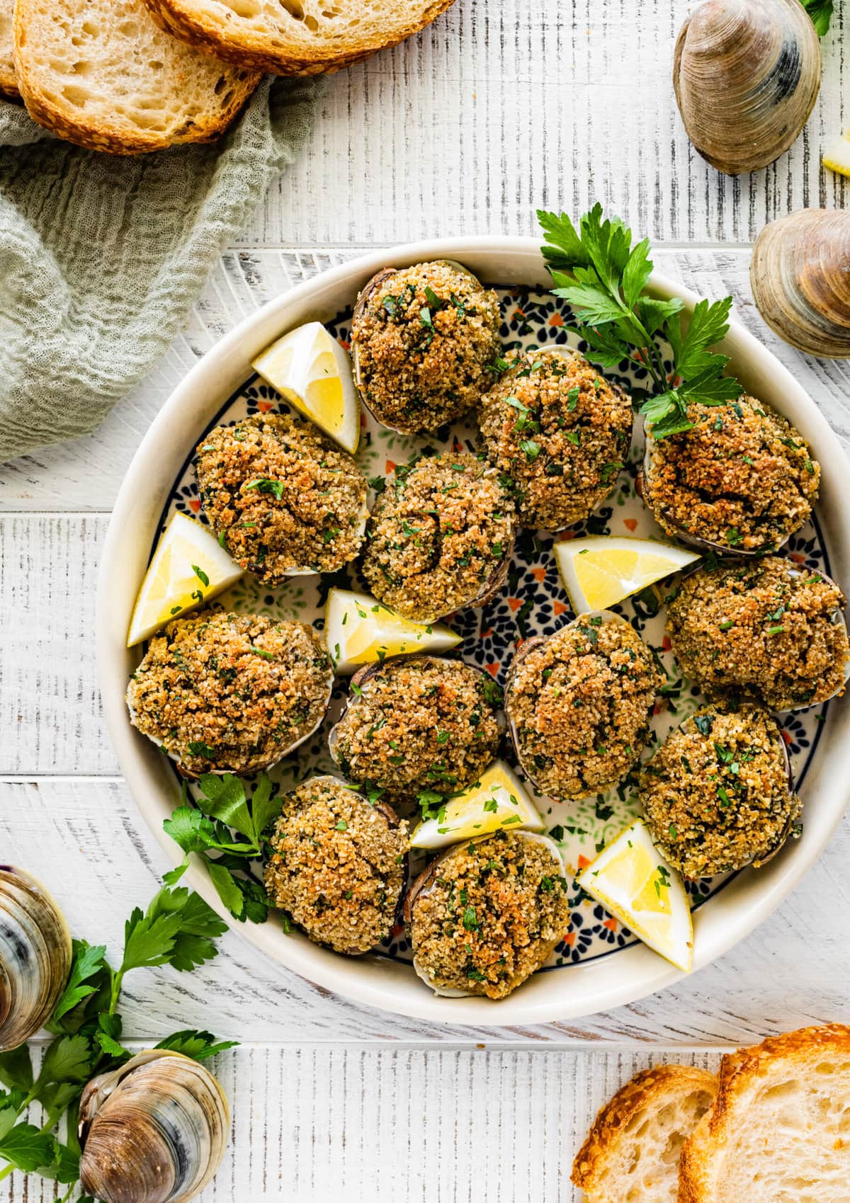 Best Italian Baked Stuffed Clams on a plate with lemon wedges and parsley. 