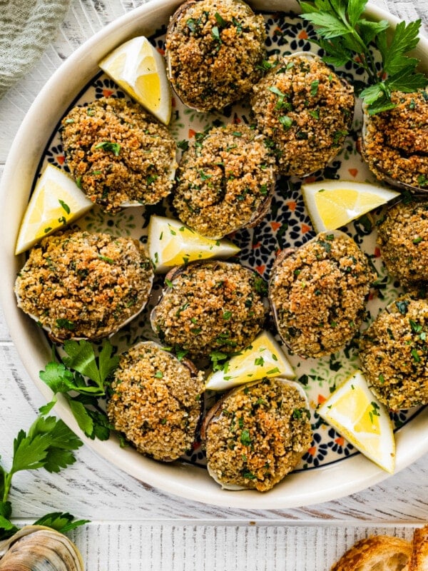 Cover image. Best Italian Baked Stuffed Clams on a plate with lemon wedges and parsley.