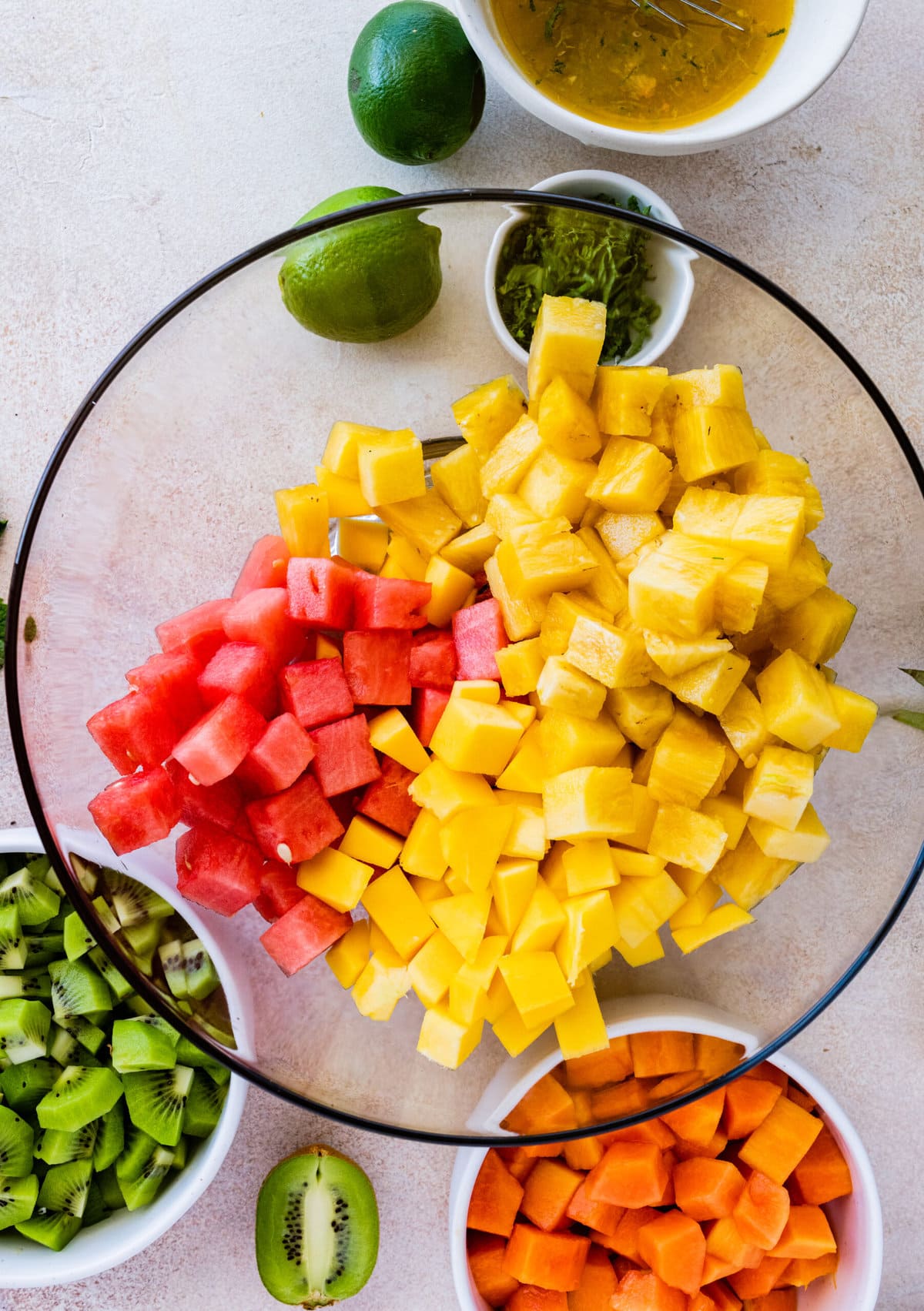 How to make Best and Easy Mexican Fruit Salad- adding all the fruit to a large glass bowl.