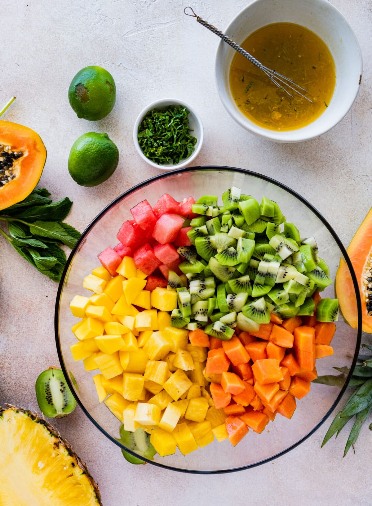 How to make Best and Easy Mexican Fruit Salad- adding all the fruit to a large glass bowl.