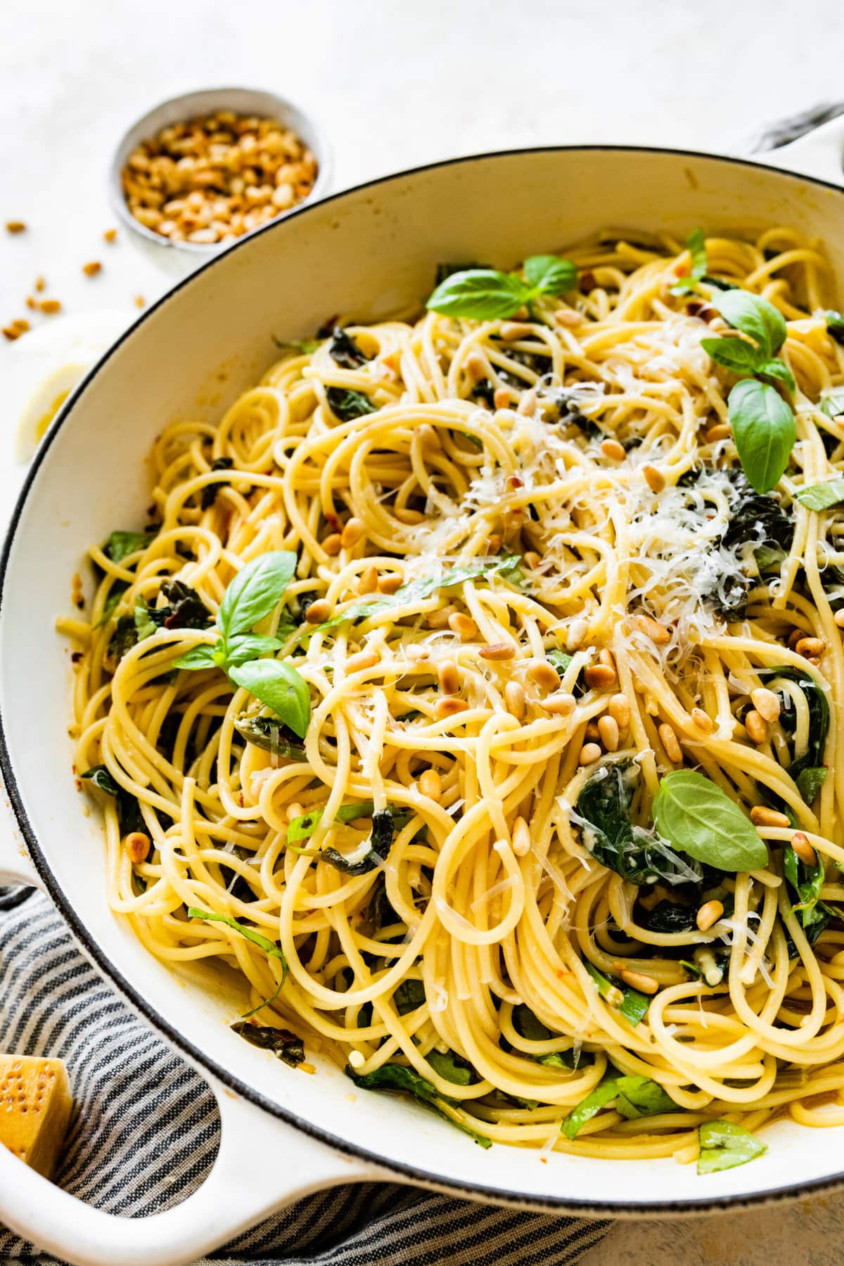 Easy Pasta with Sautéed Spinach and Garlic- in a a serving platter with extra basil and cheese as garnish.