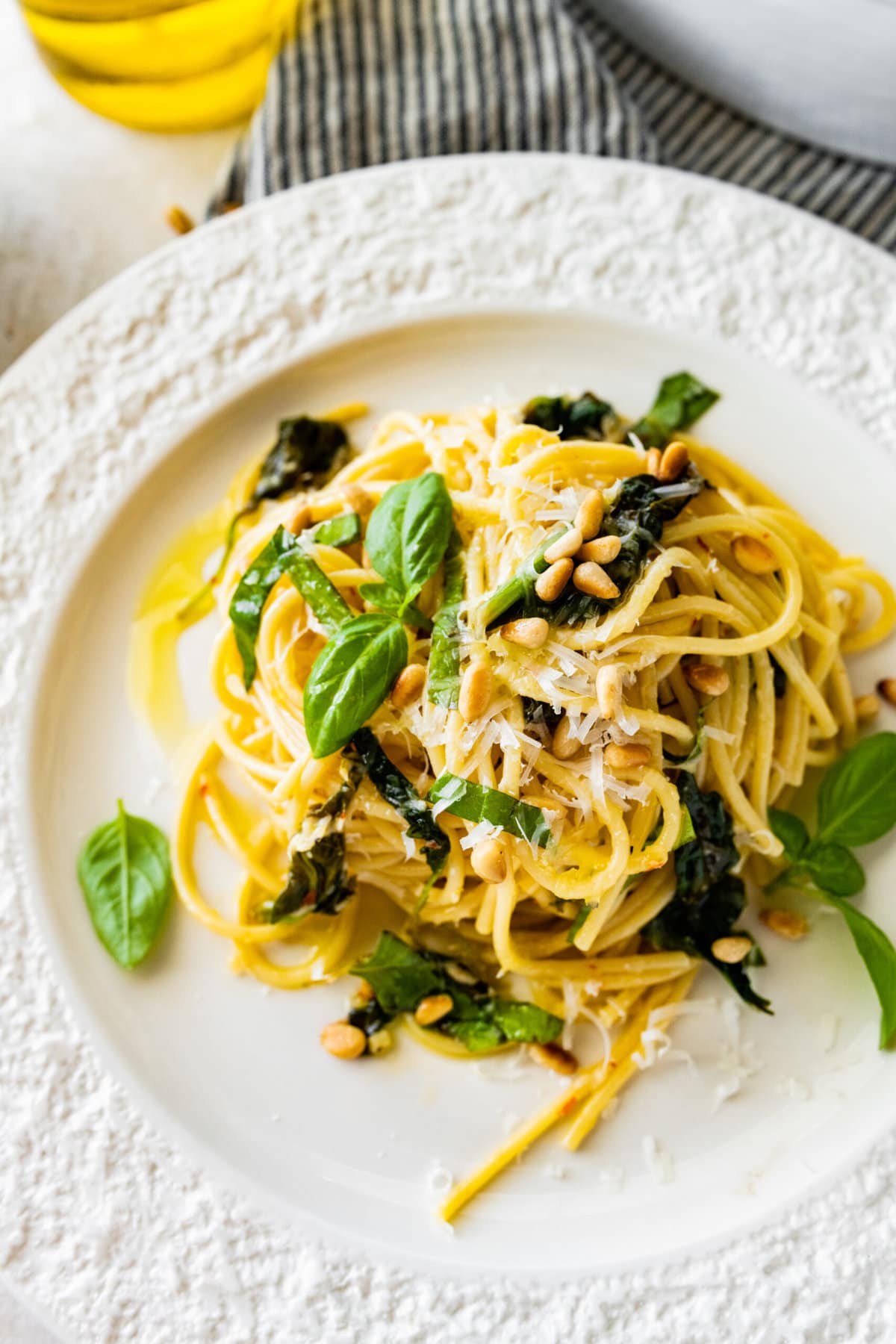 a plate with a portion of Easy Pasta with Sautéed Spinach and Garlic toasted pine nuts on top.