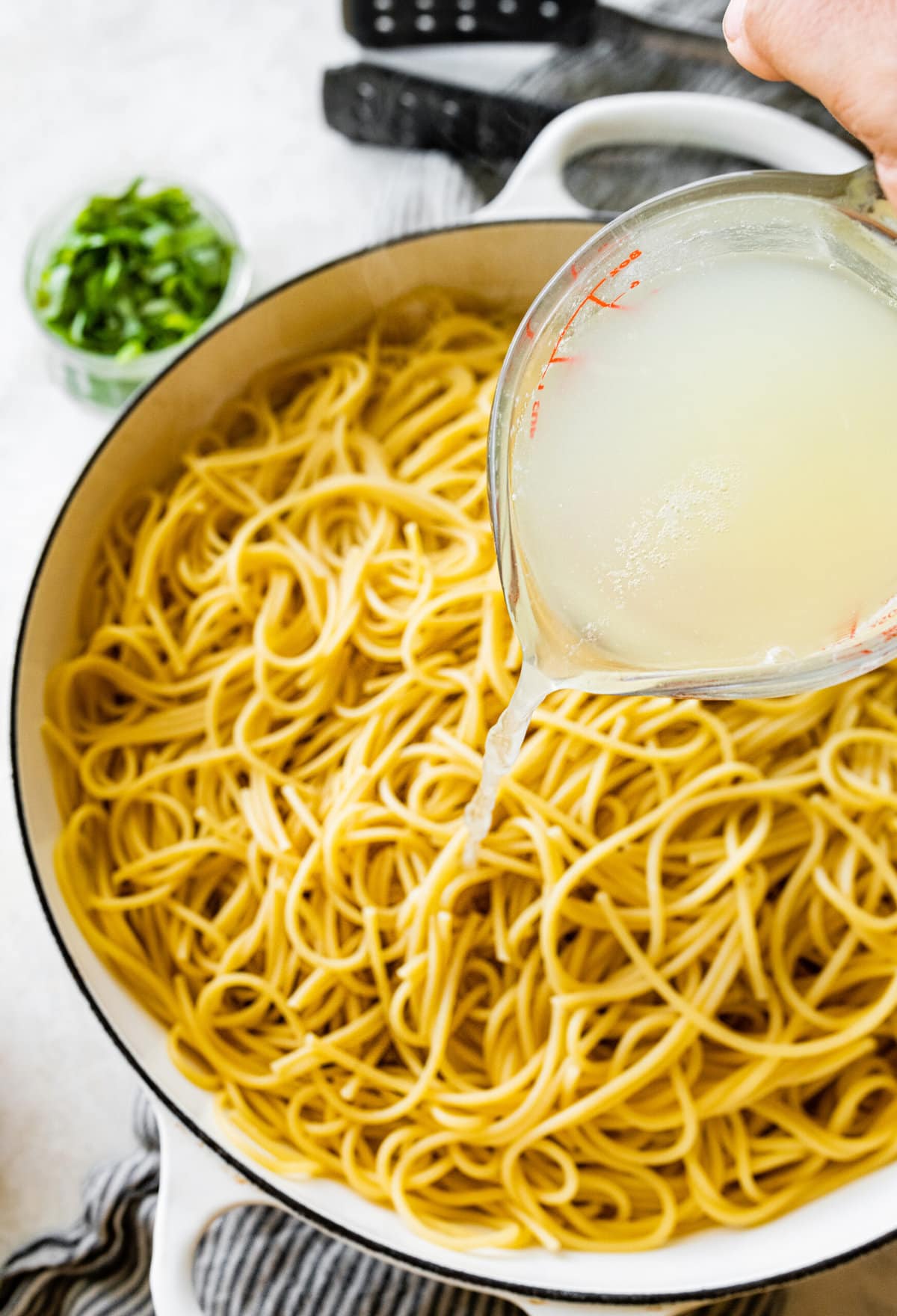 How to make- Easy Pasta with Sautéed Spinach and Garlic- adding cooked spaghetti and pasta water to the pan.