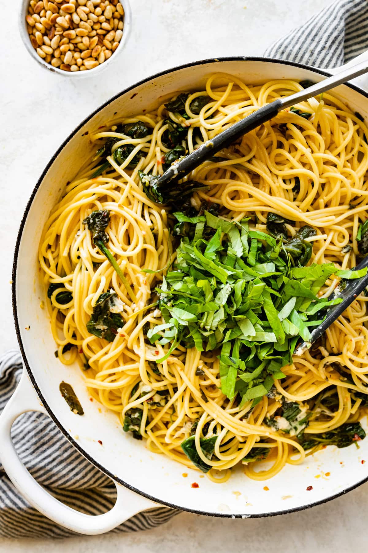 How to make- Easy Pasta with Sautéed Spinach and Garlic- adding basil and toss to combine.