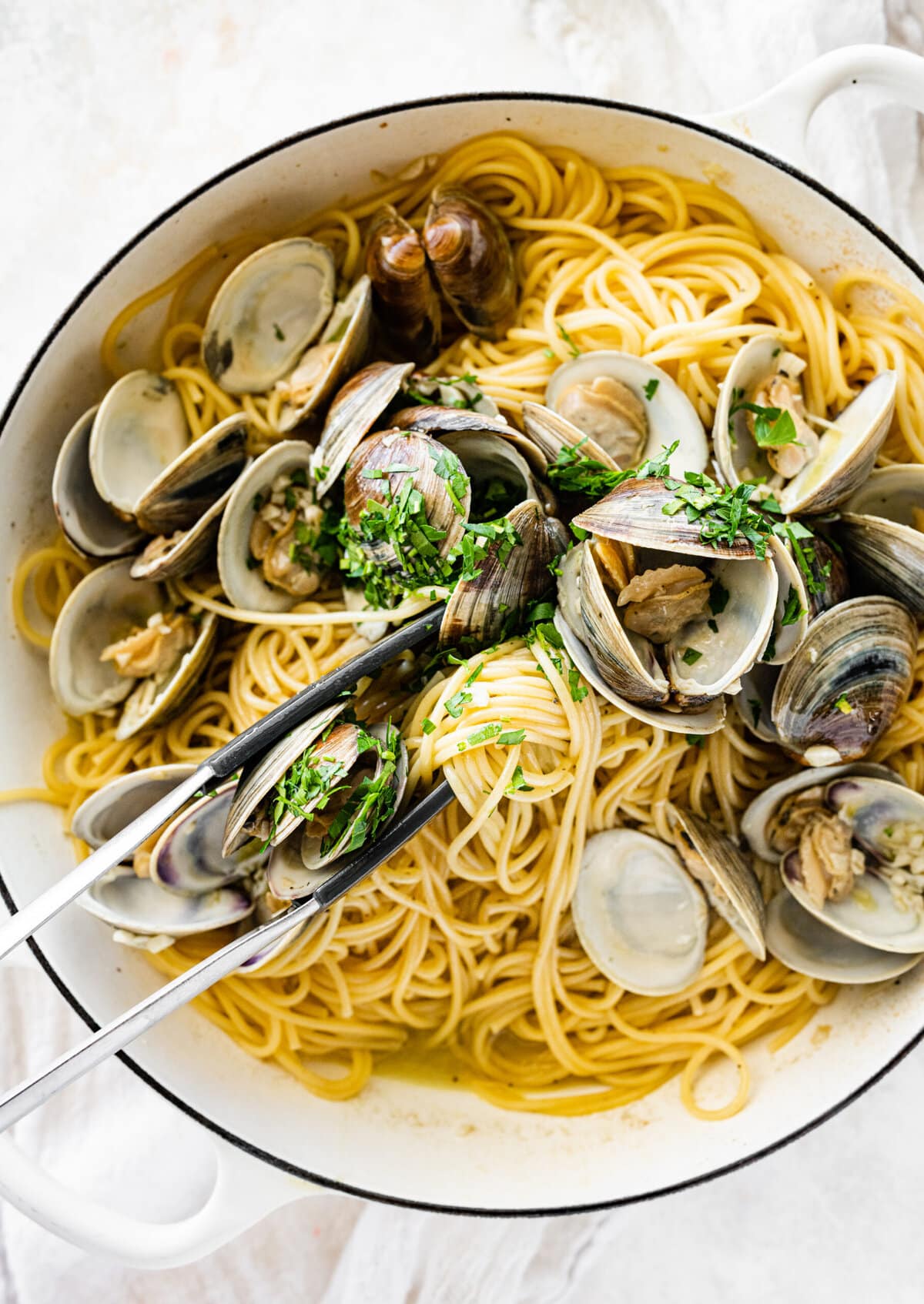 How to make- Spaghetti alle Vongole Recipe (Pasta with Clams)- tossing the spaghetti with the clams in the pan.