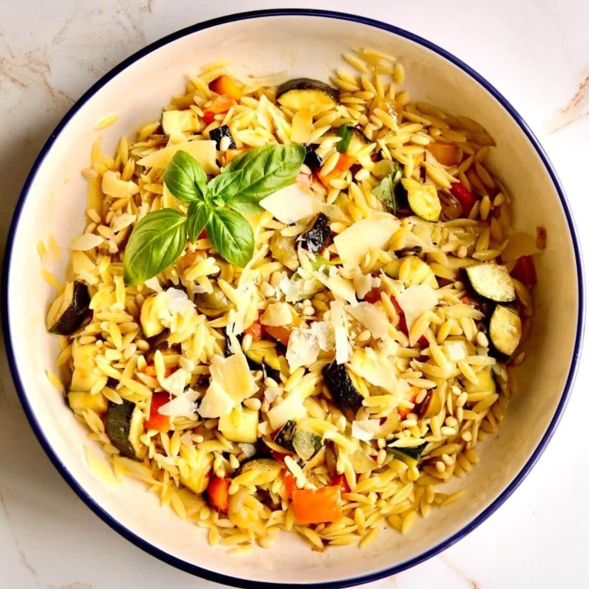 Orzo pasta salad in a bowl with basil