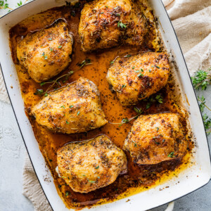 Six chicken thighs in a baking dish.