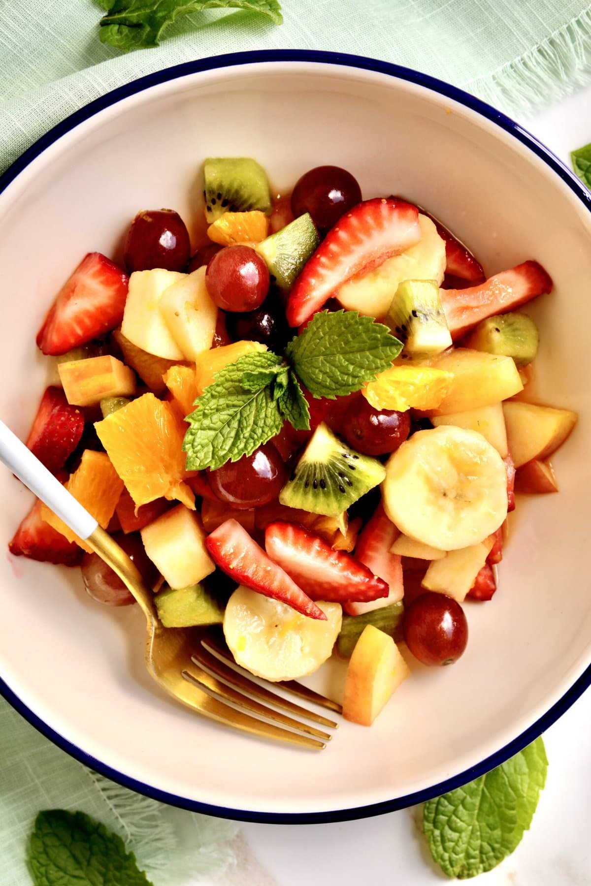 Italian Fruit Salad Recipe (Macedonia di Frutta)- in a bowl with a fork in it ready to eat. Top down view.