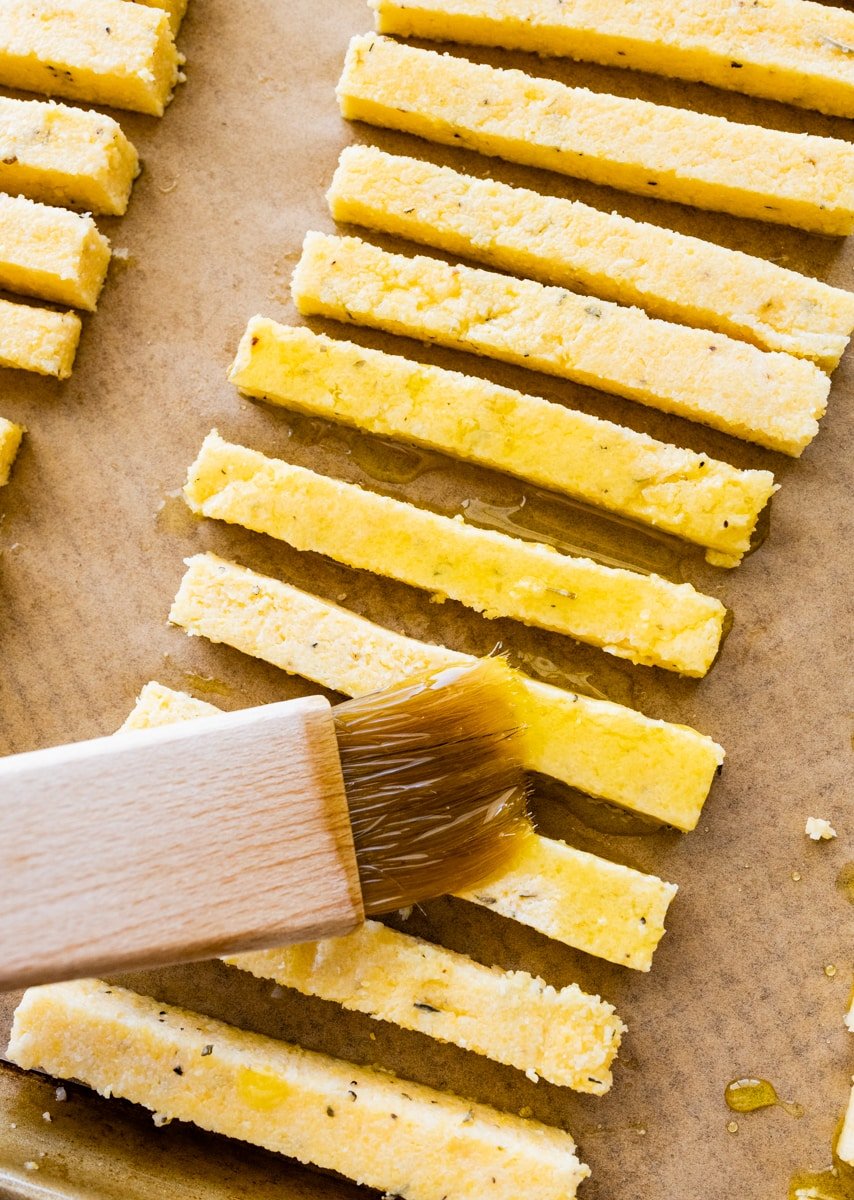 How to make crispy polenta fries step-by-step: brushing the fries with olive oil.
