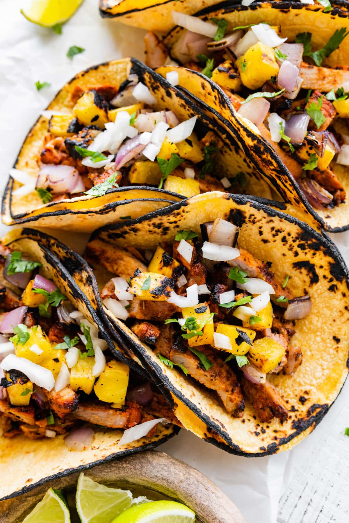 Pastor tacos on a serving platter assembled and ready to eat. 