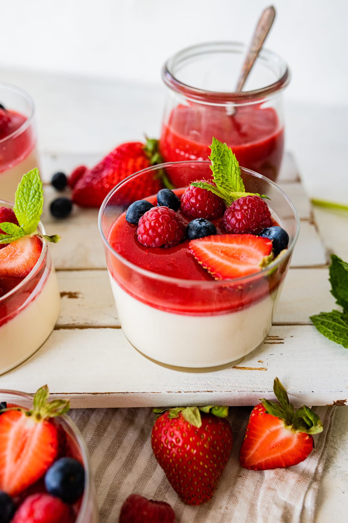 side view of panna cotta and berries in a glass cup to se layers. fresh berries as decoration. 