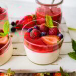 Panna cotta topped with berries in a small glass.
