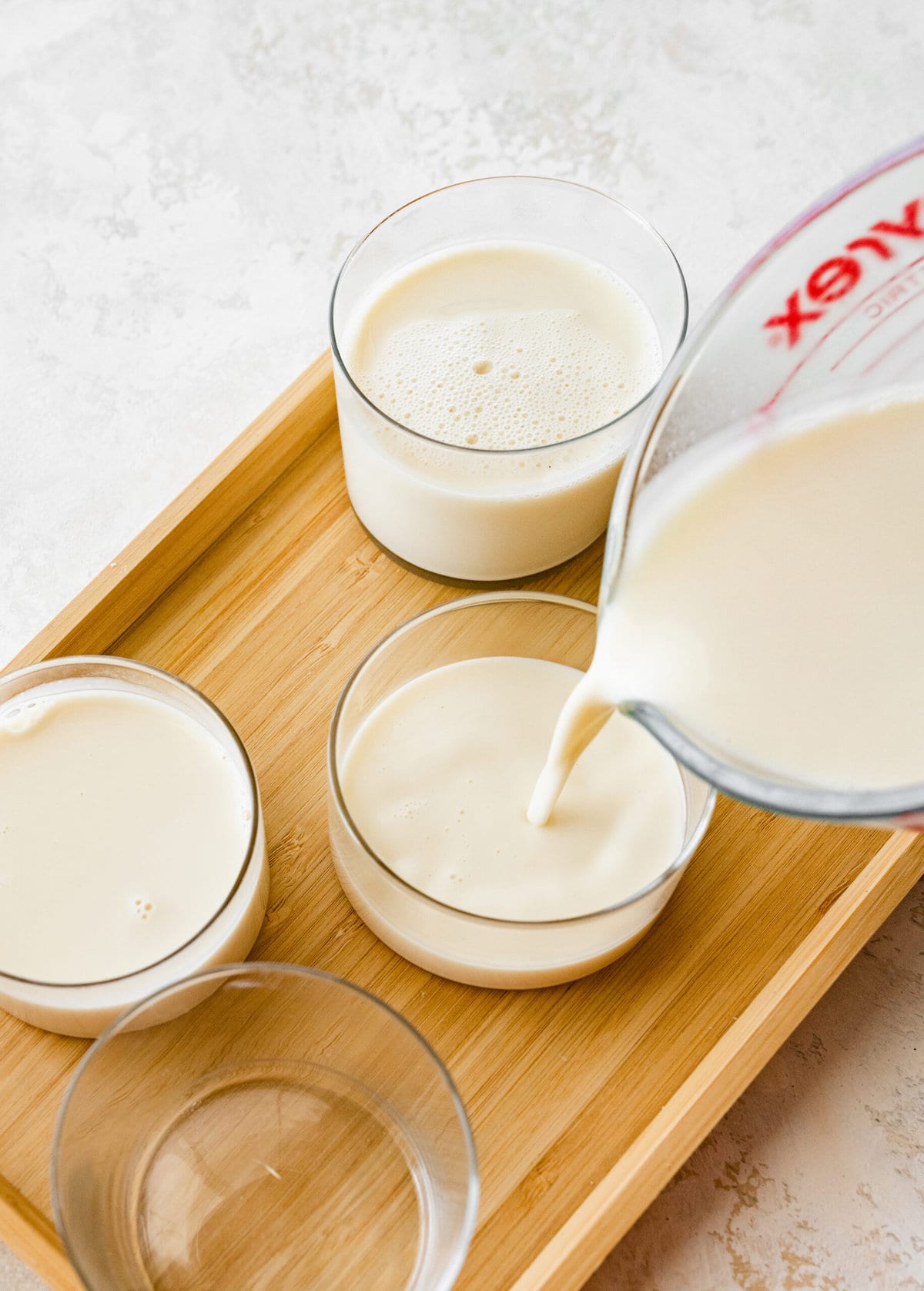 How to Make Classic Italian Panna Cotta Recipe Easy- pouring ingredients in cups.