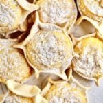 Best Sardinian Pardulas Recipe (Ricotta Cakes)- close up of baked pardulas with powdered sugar.
