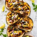 Homemade Tacos Al Pastor Recipe (Tacos De Trompo)- assembled tacos on a plate ready to eat. Limes and parsley on the side.