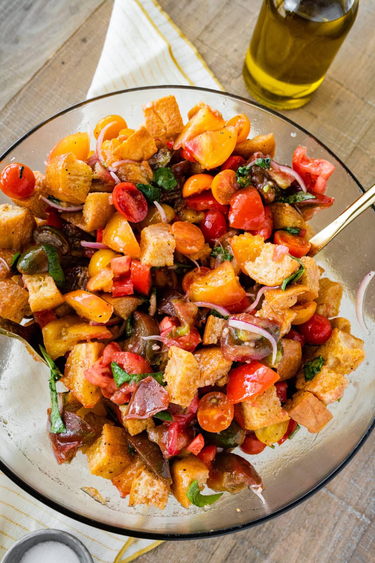 Best Summer Panzanella Salad Recipe (Bread & Tomato)- mixing all the ingredients together in a bowl with salad servers.