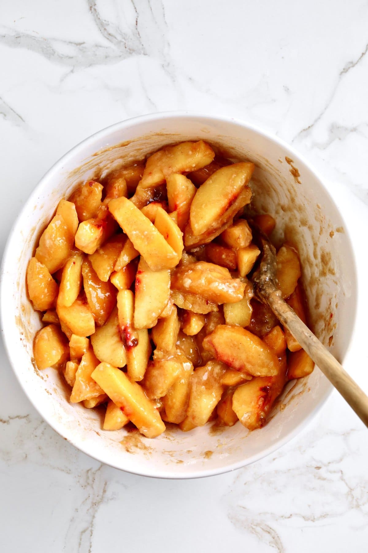 How to make fresh peach pie recipe step-by-step: mixing peaches with dry ingredients for filling.