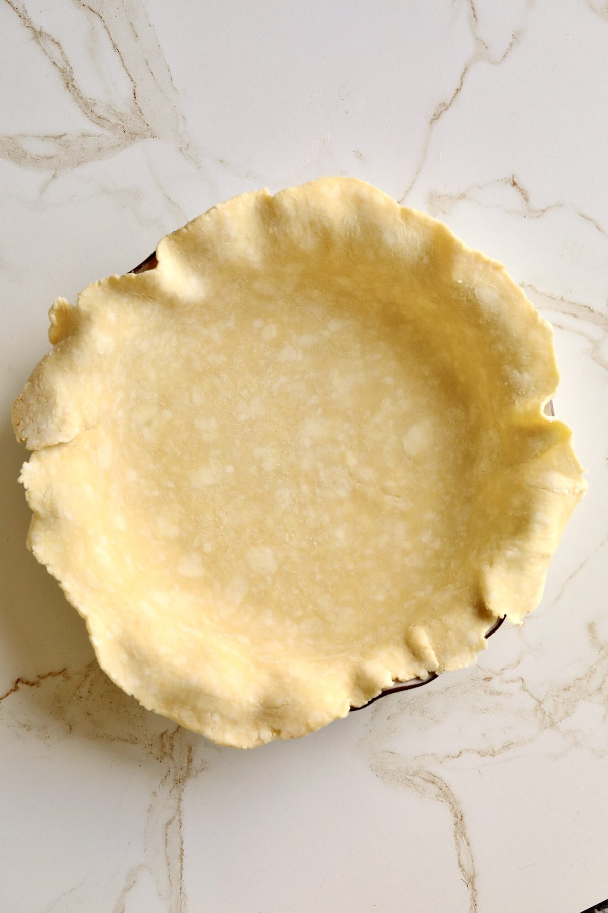 How to make fresh peach pie recipe step-by-step: placing bottom crust in pie dish.