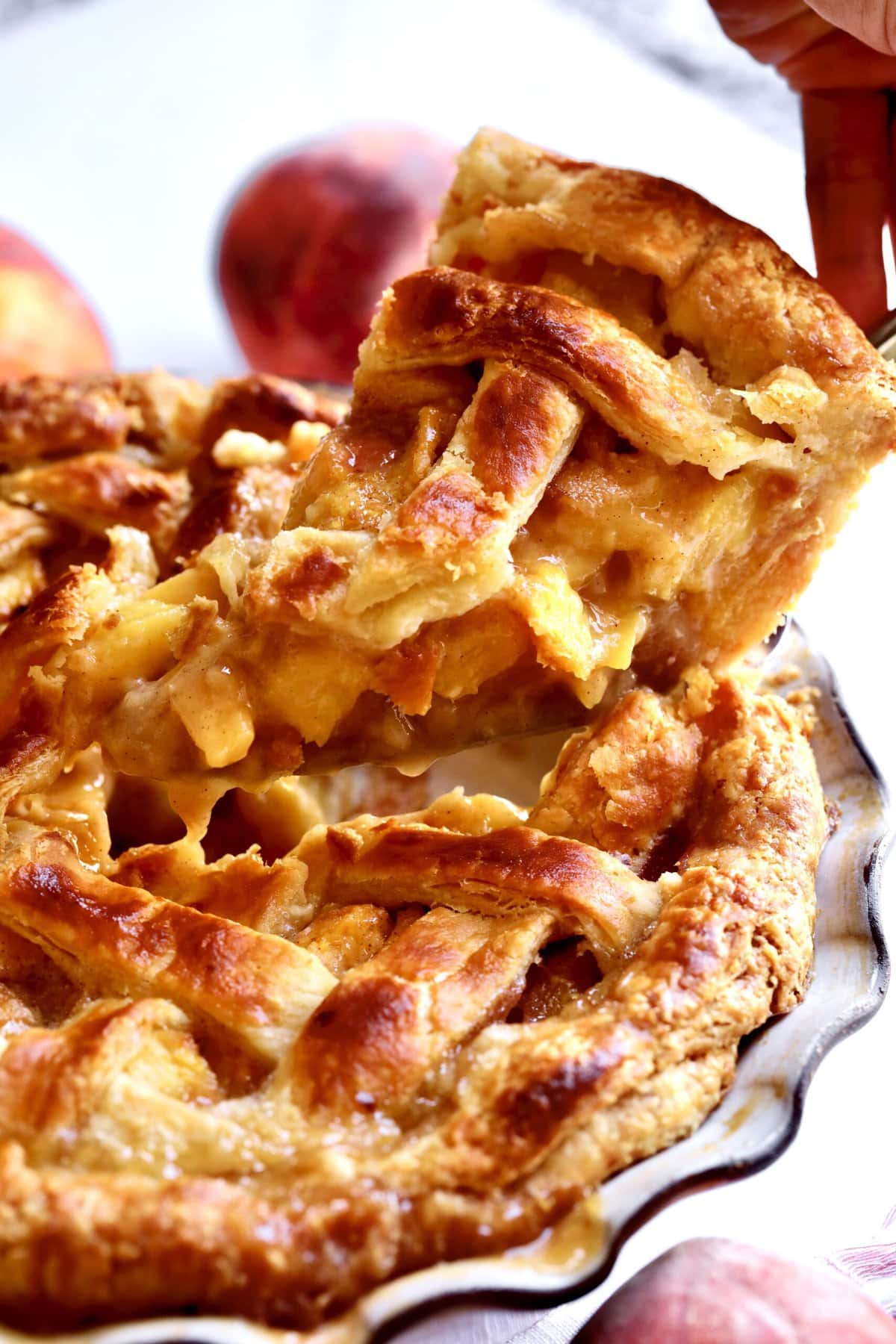 taking a slice out of the perfect peach pie with flaky crust.