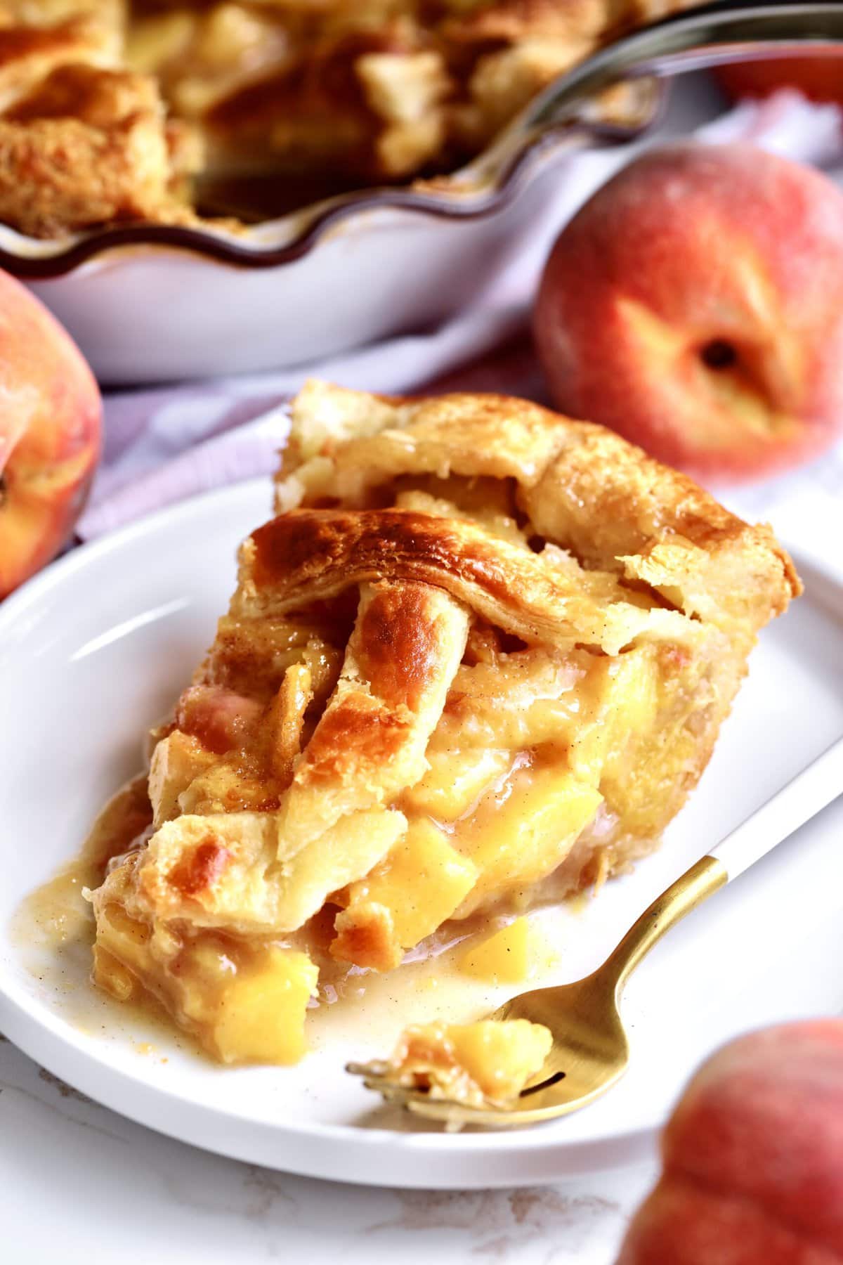 slice of the perfect peach pie on a plate with a fork.