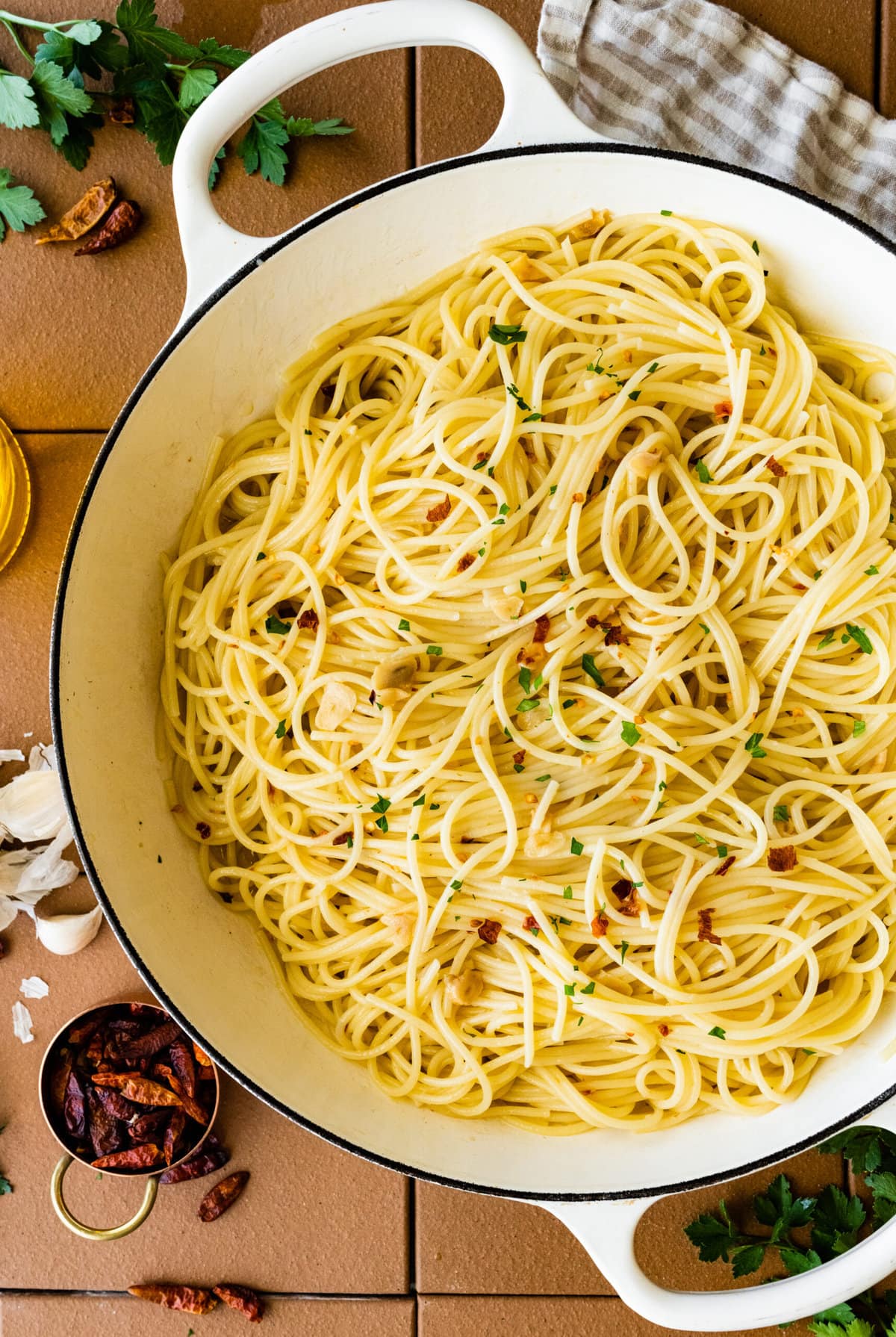 finished aglio e olio recipe in pan with a little parsley on top.