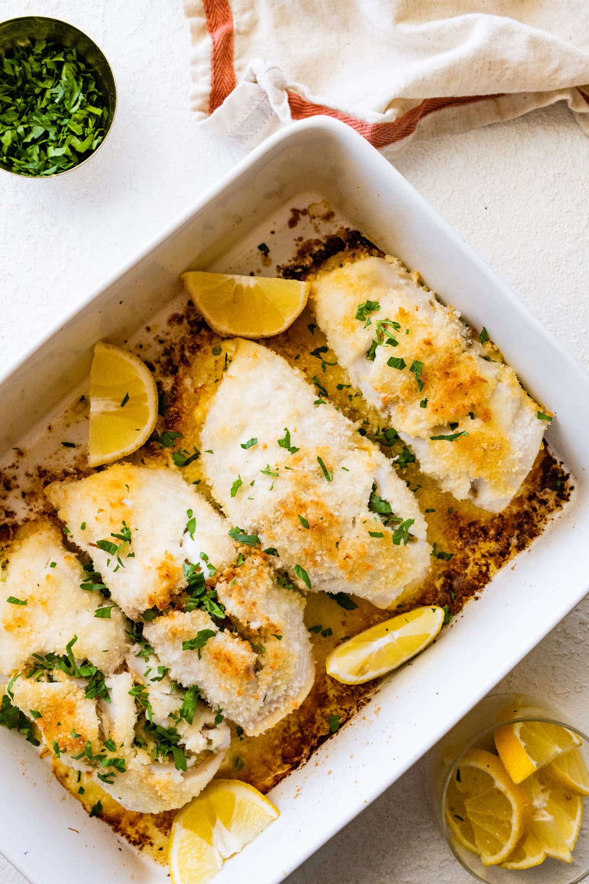 How to make stuffed flounder recipe- baked fish out of the oven in a white pan. Serve with lemon wedges.