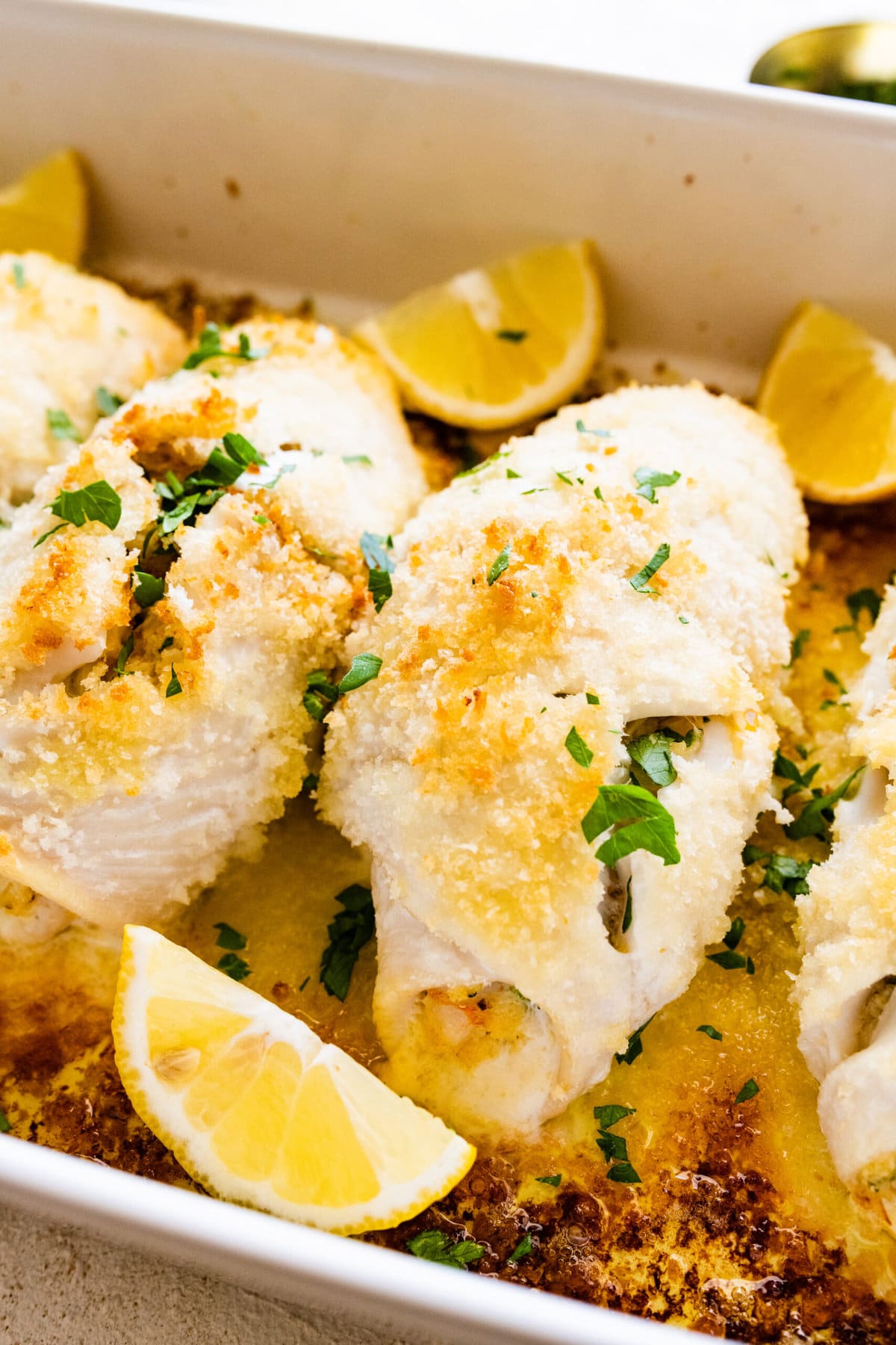 How to make stuffed flounder recipe- baked fish out of the oven in a white pan. Serve with lemon wedges.