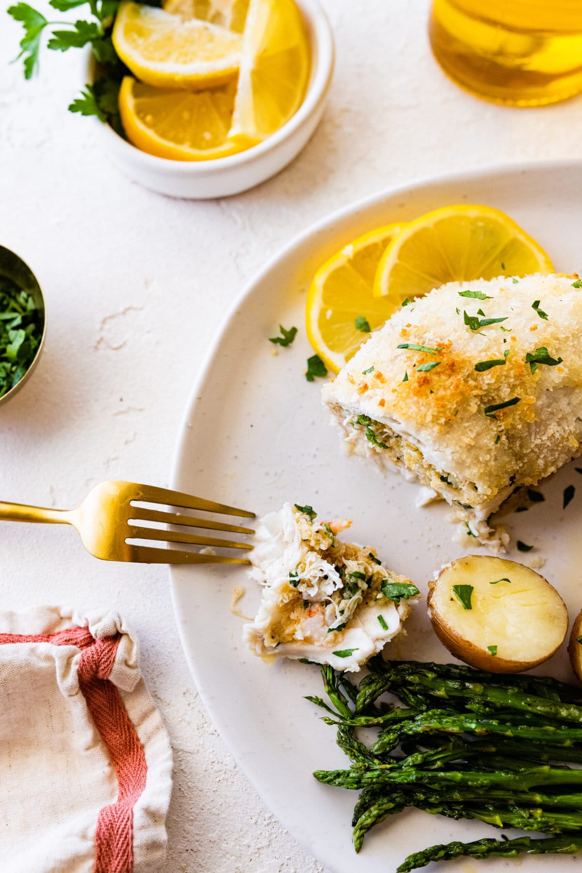 sliced baked flounder showing the stuffing. on a plate.