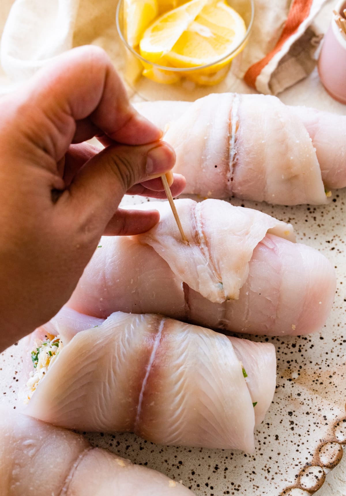 How to make stuffed flounder recipe- placing a toothpick in the middle so the filling and fish stay together.