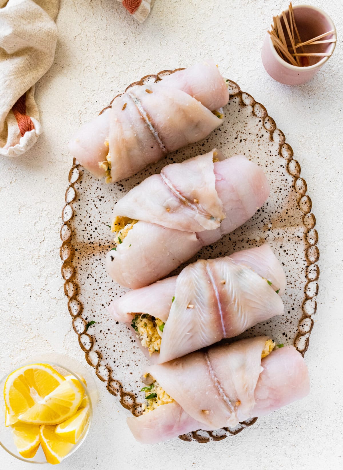 How to make stuffed flounder recipe- placing fish in a serving dish with olive oil.