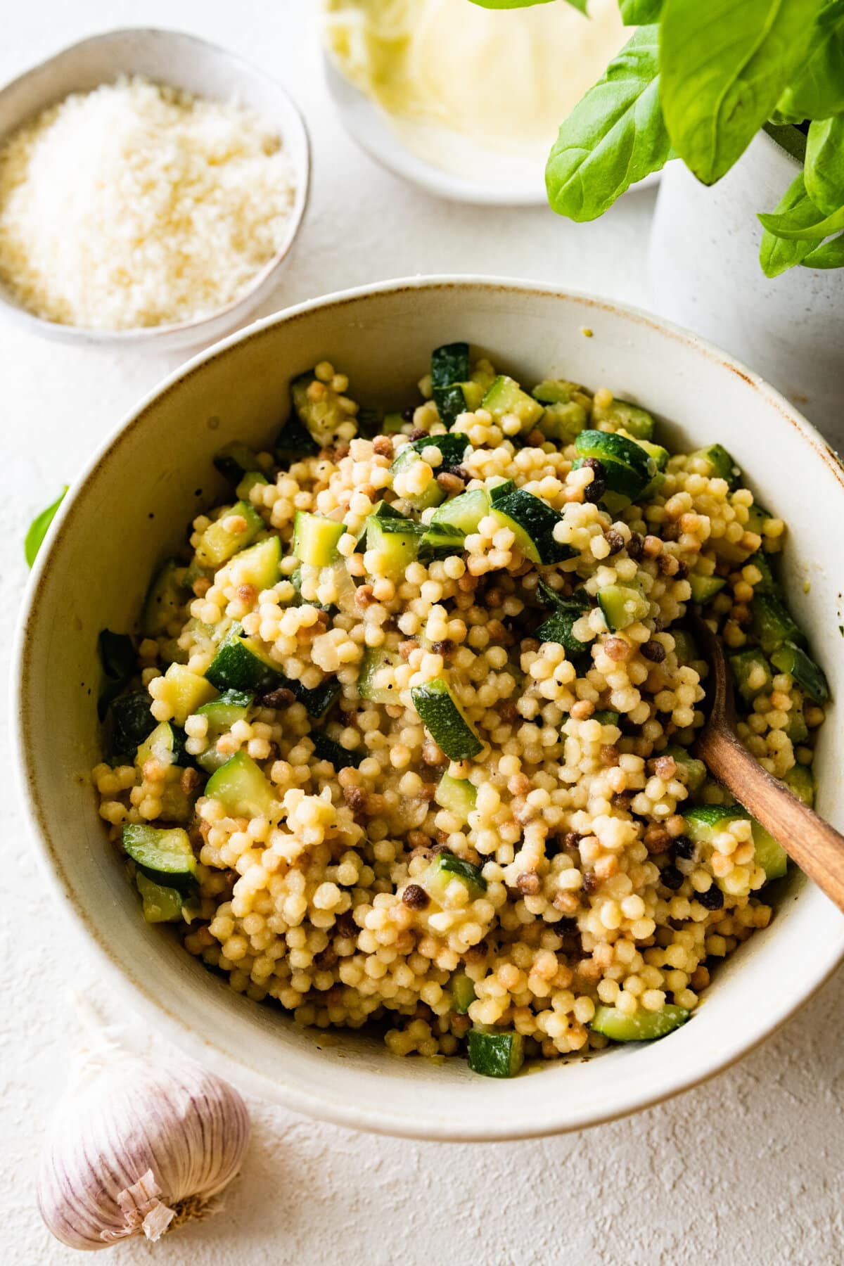 Step by step instructions Fregola Sarda Pasta Recipe with Zucchini and Cheese- mixing zucchini and onions with fregola.