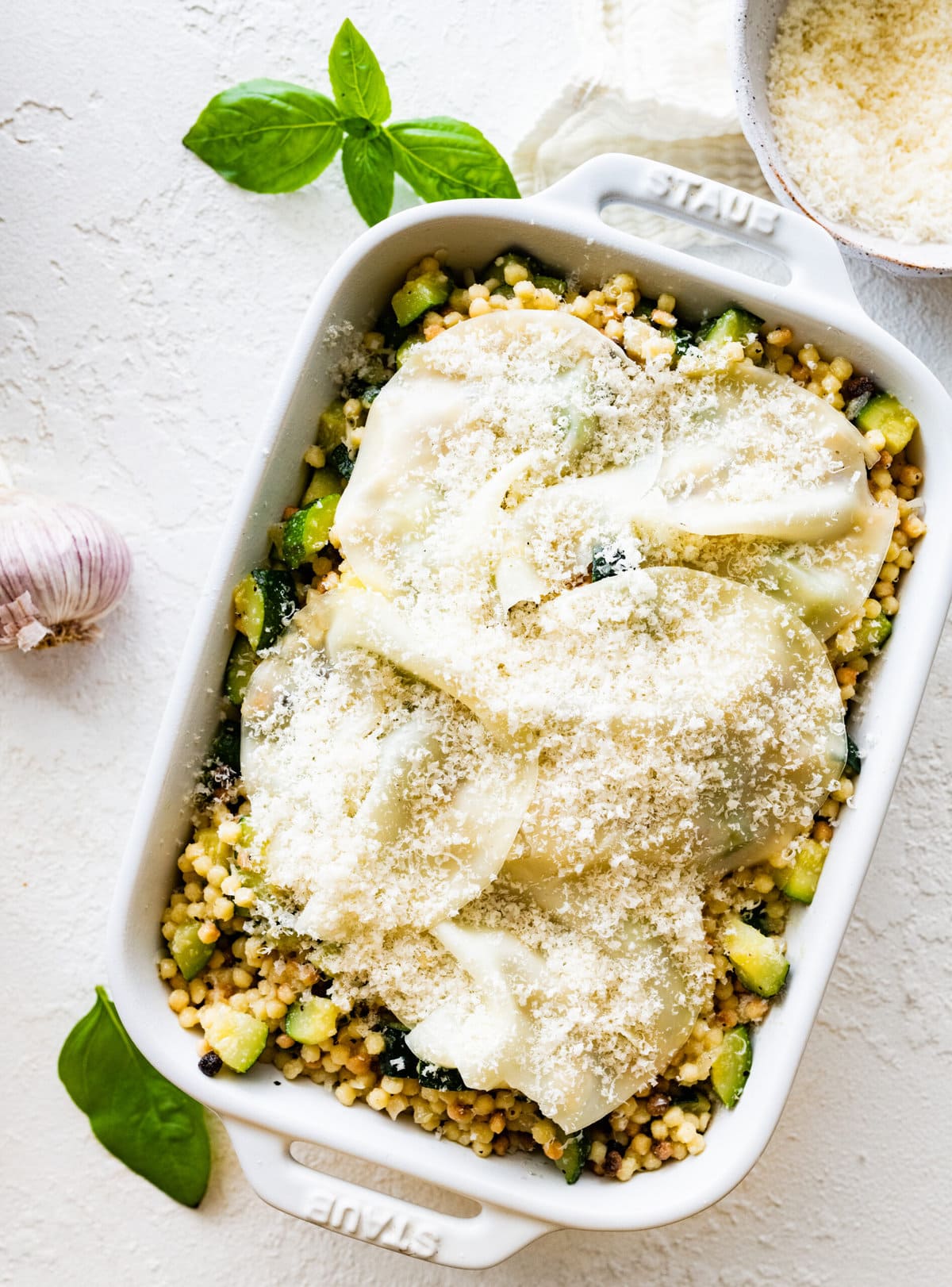 Step by step instructions Fregola Sarda Pasta Recipe with Zucchini and Cheese- Add final layer of cheese before baking.