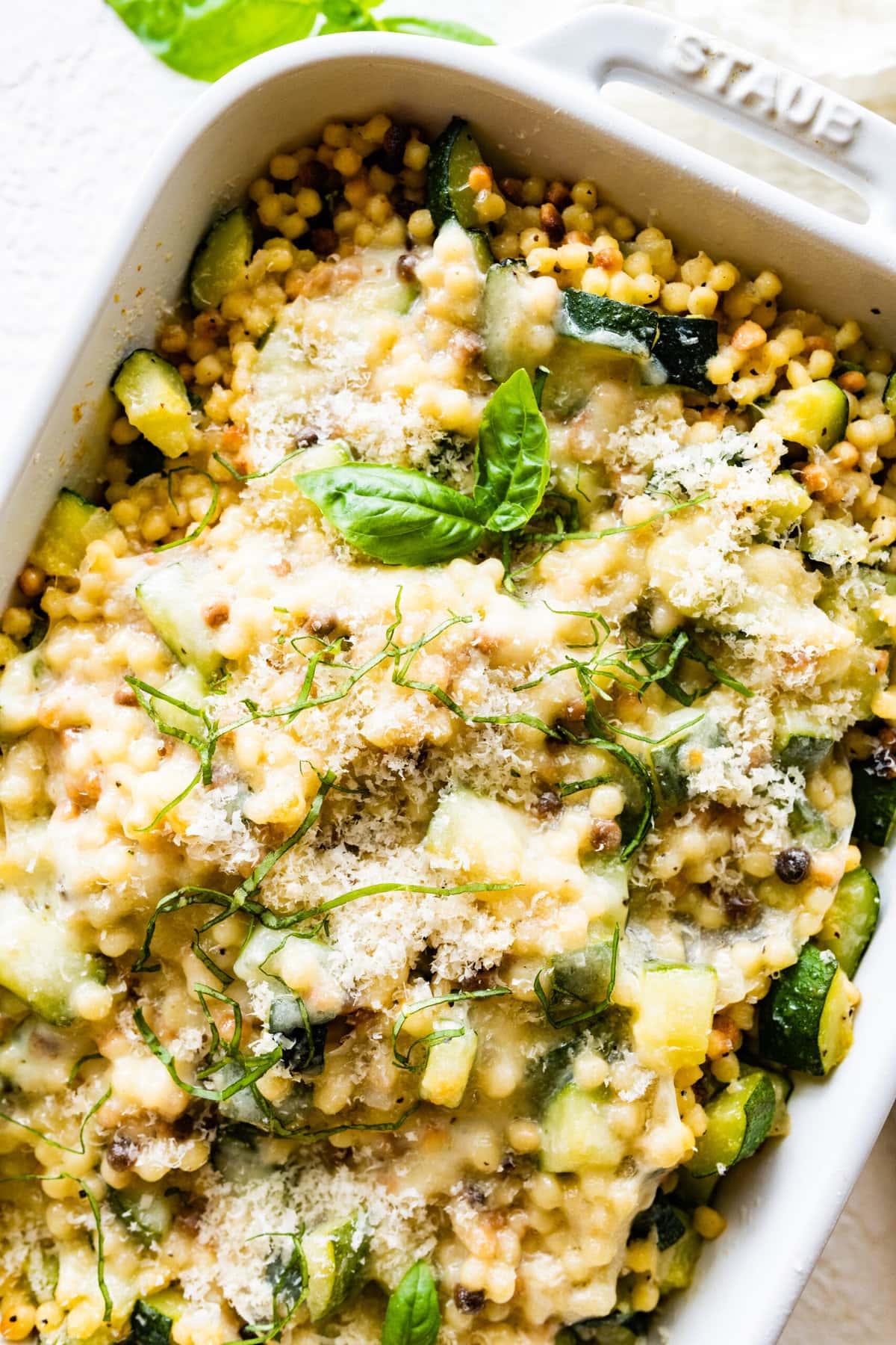 Step by step instructions Fregola Sarda Pasta Recipe with Zucchini and Cheese- after baking. Soft and melted cheese on top.