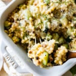 finished Fregola Sarda Pasta Recipe with Zucchini and Cheese in pan. Up close shot with wood spoon taking out a portion.