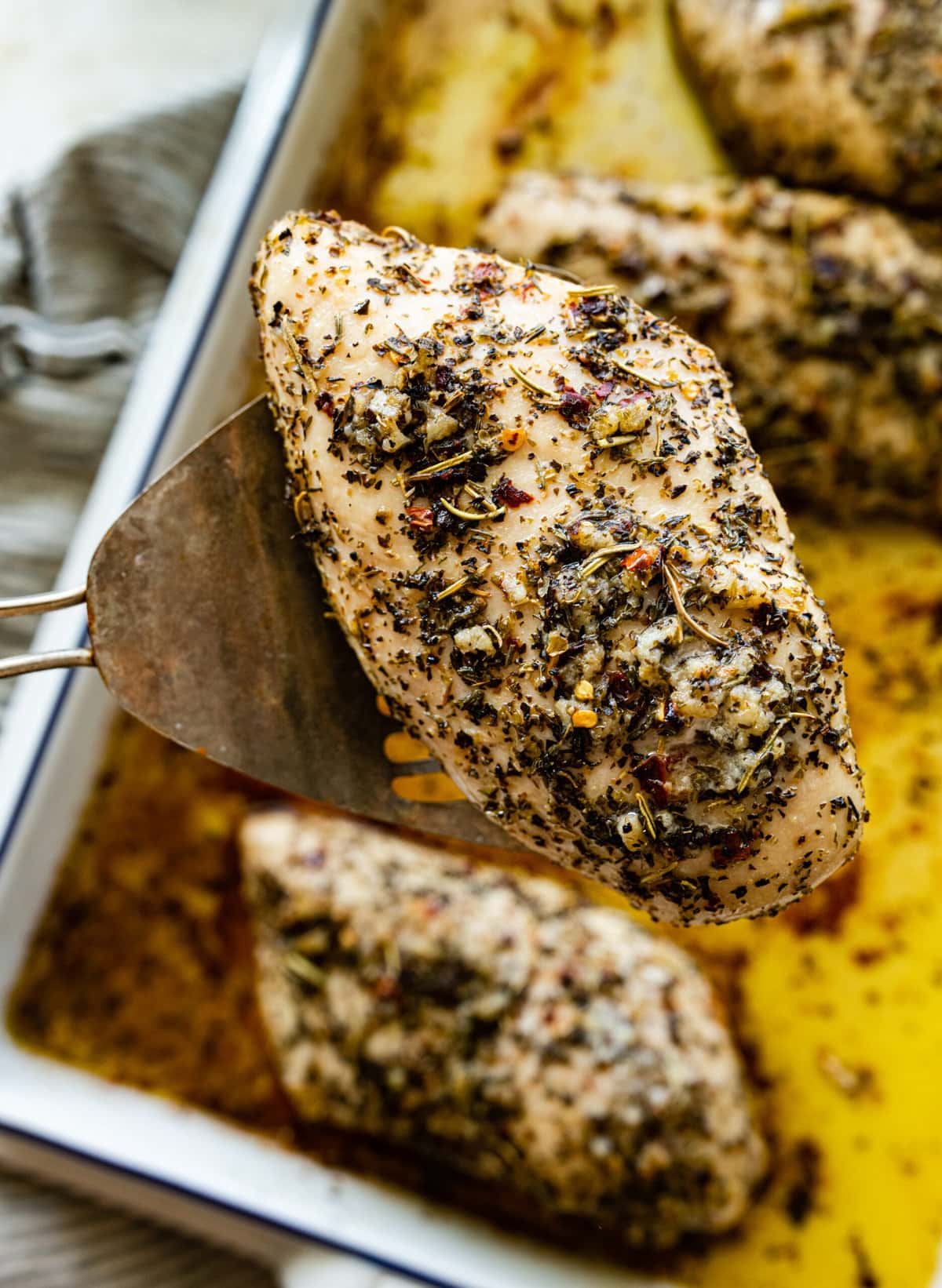 close up of baked chicken on a spatula.